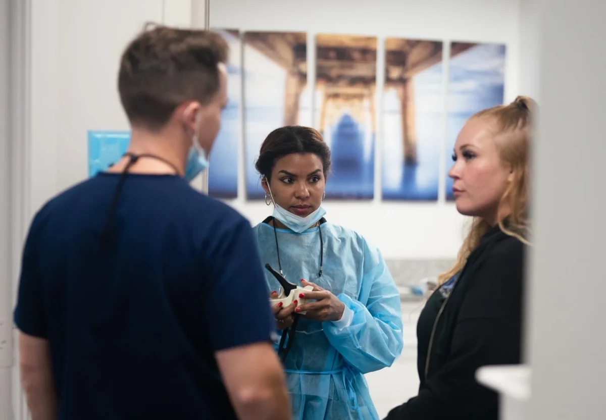 Three people in medical attire discussing