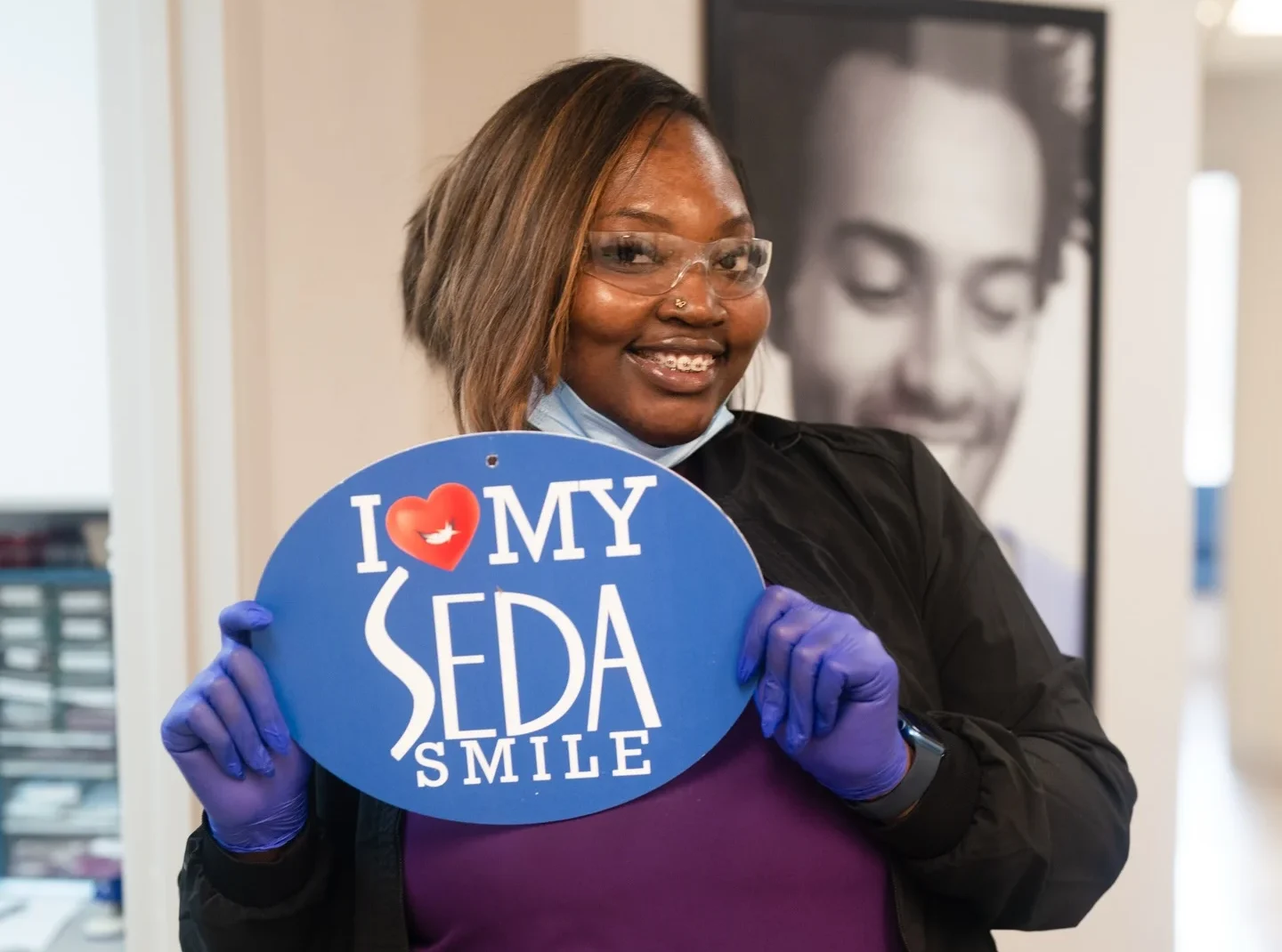 Smiling person holding a sign